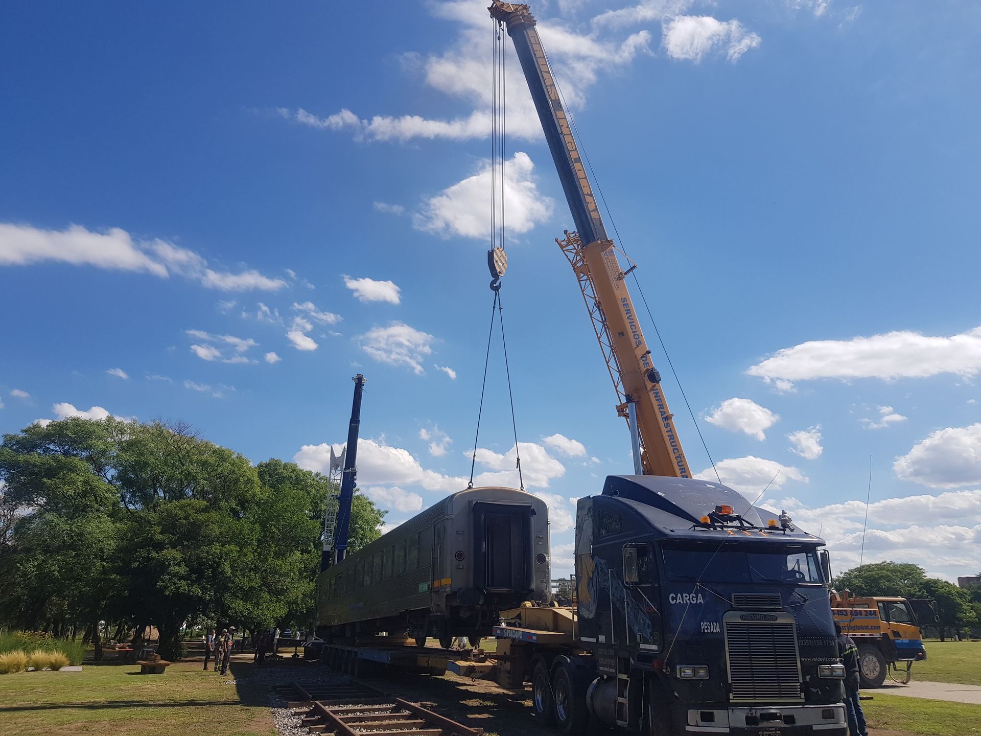Un camión es levantado por una grúa en un día soleado. - Grúas Inglobal SRL