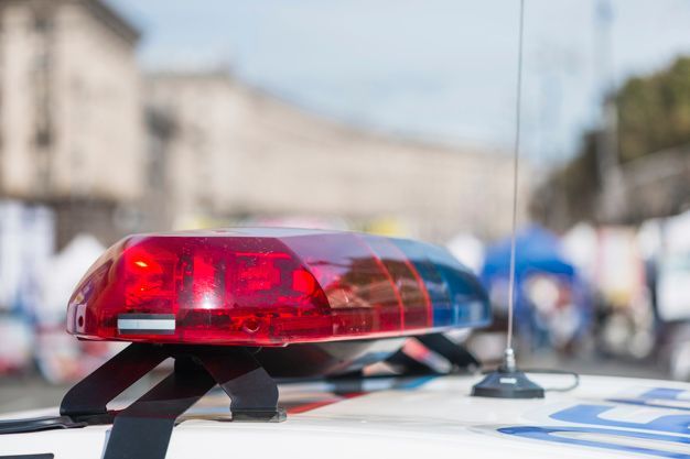 um close de uma luz policial vermelha e azul em cima de um carro da polícia.
