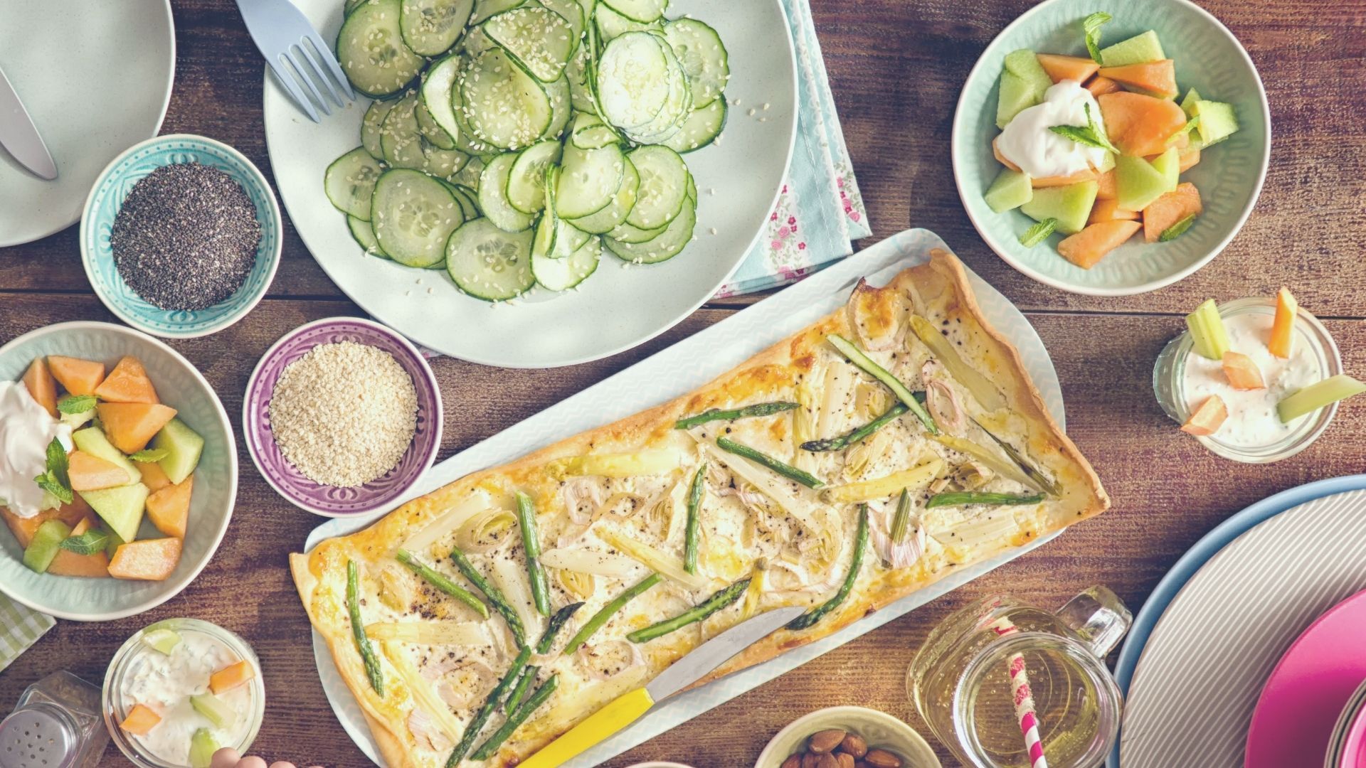 uma mesa com pratos de comida e tigelas de frutas.