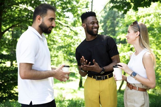 um grupo de pessoas está em um parque conversando entre si.