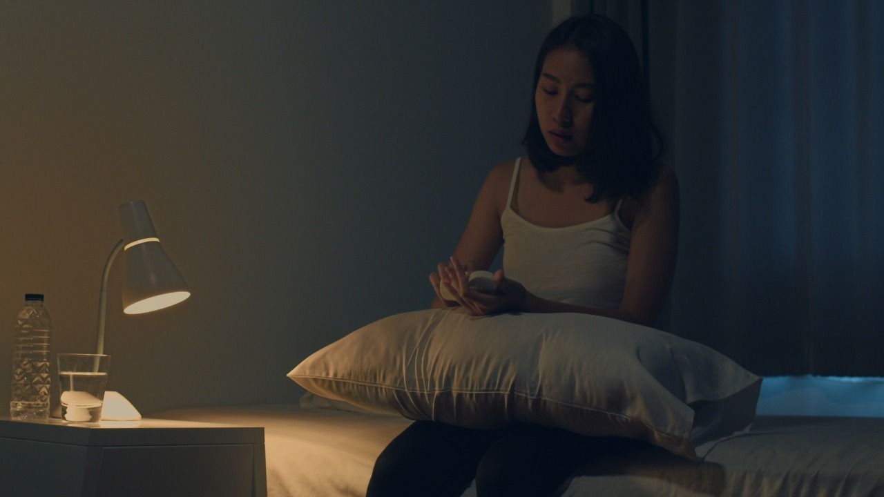 quarto escuro com uma moça triste