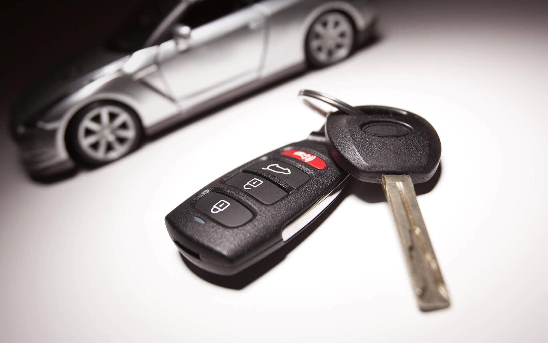 Una llave de auto está sentada frente a un auto de juguete