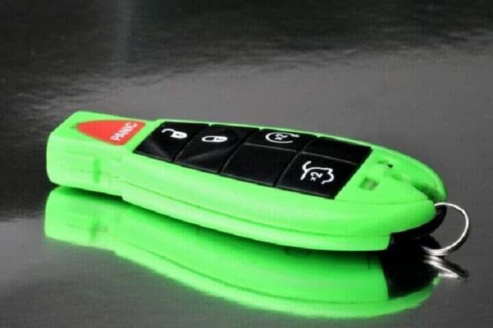 Una llave de coche verde sentada sobre una superficie negra