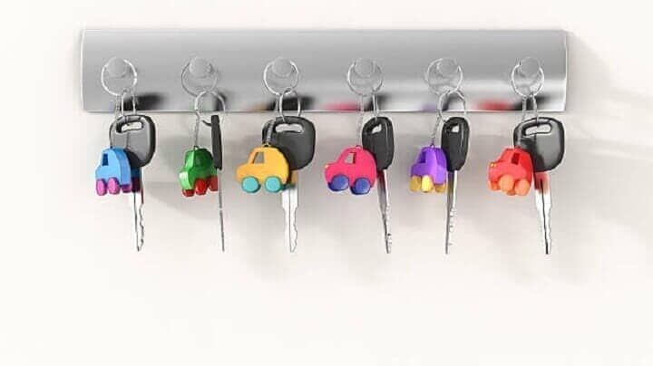 Un manojo de llaves colgadas en un estante con carritos de juguete.