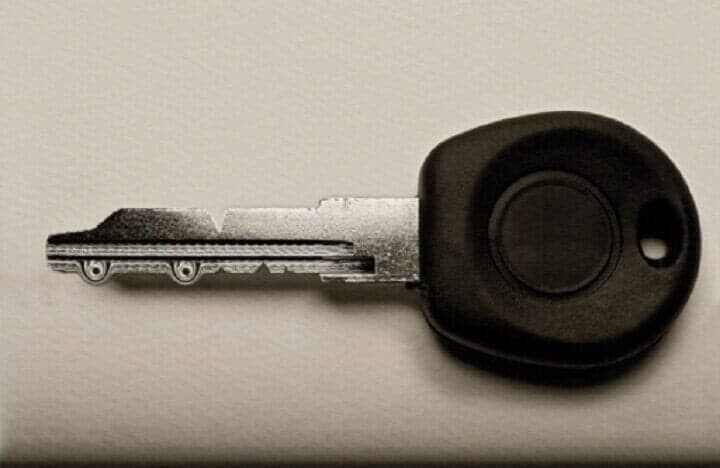 Un primer plano de la llave de un coche sobre una superficie blanca