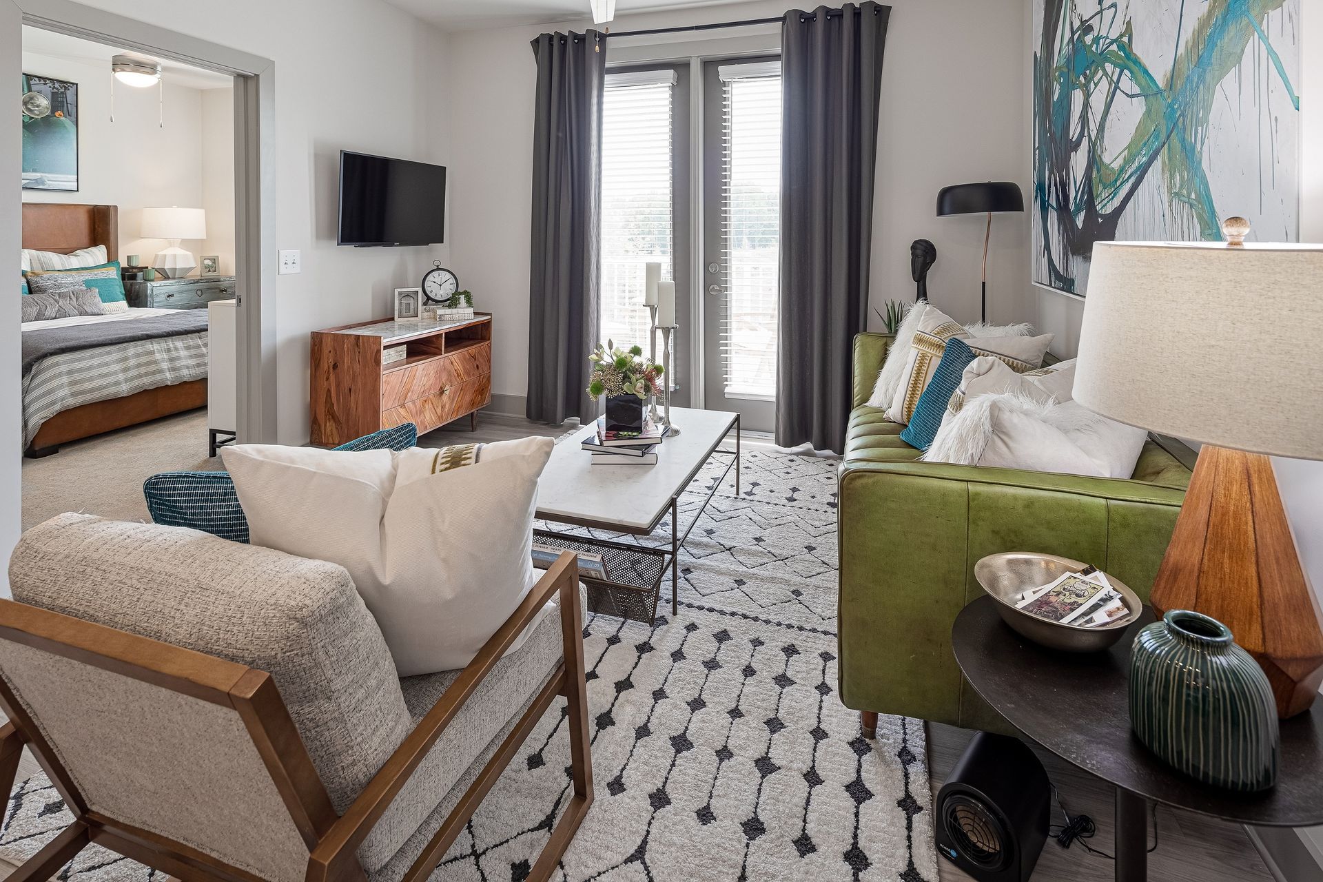 A living room with a green couch , chairs , coffee table and television.
