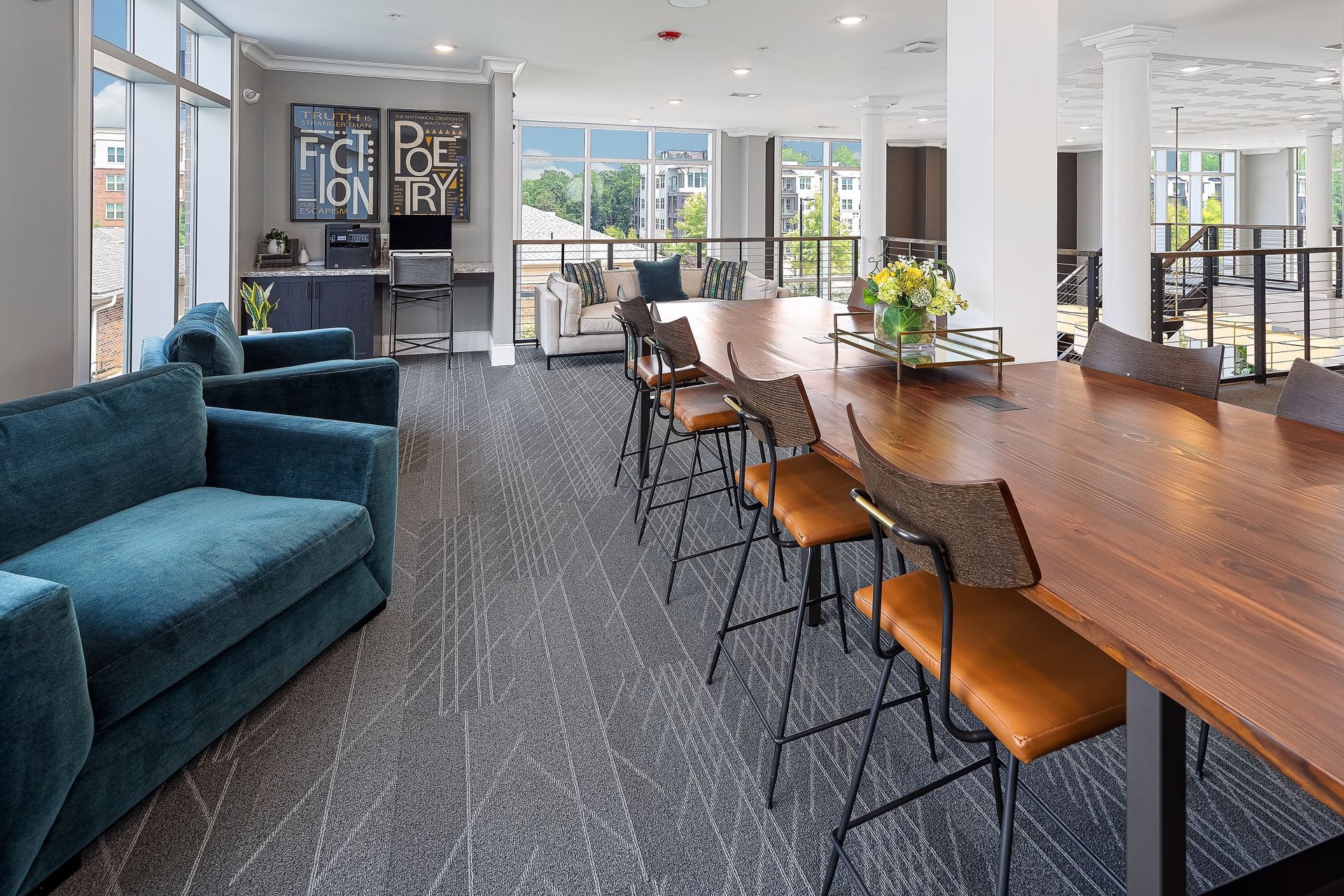 A living room with a couch , chairs and a long table.