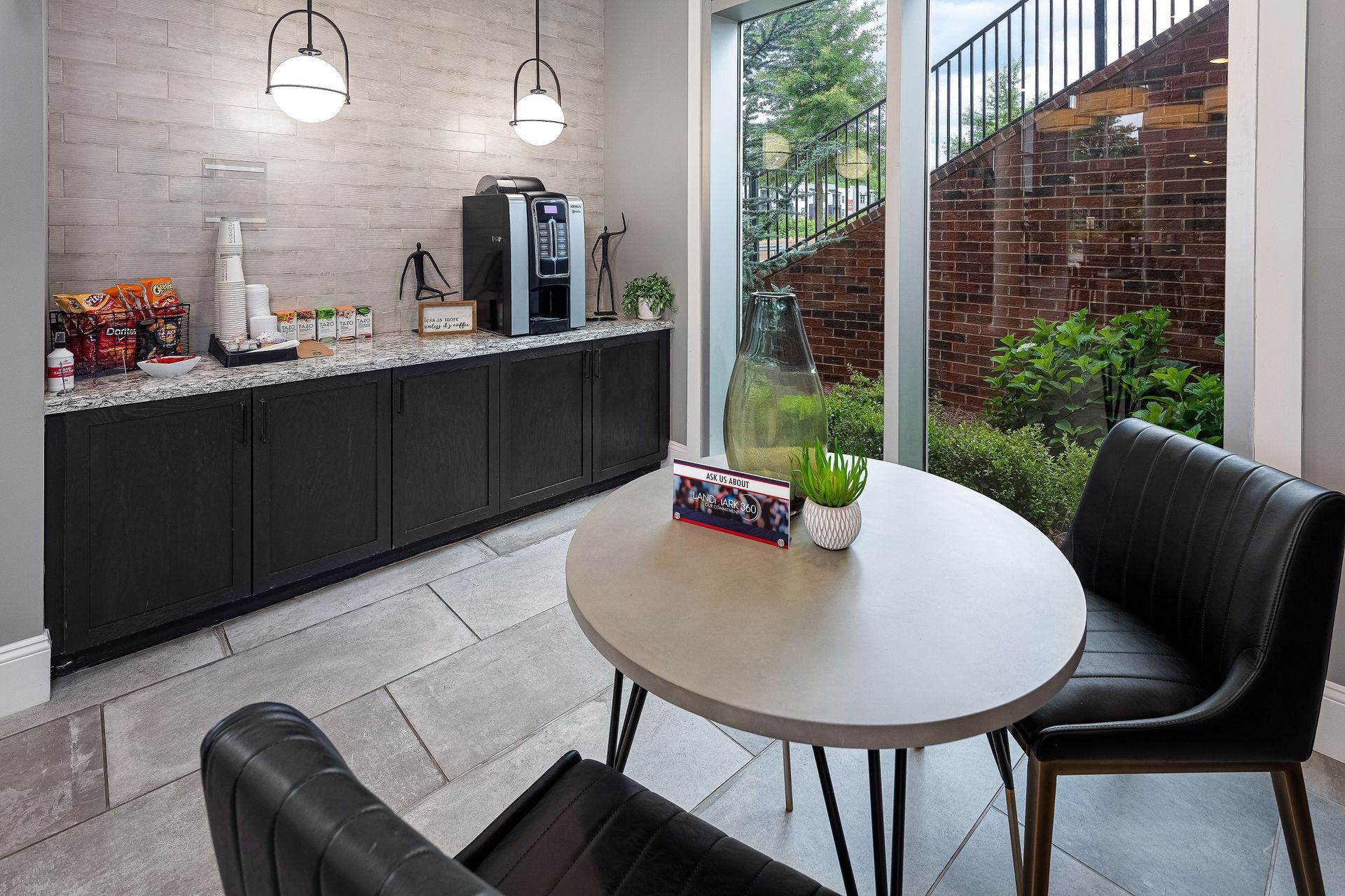 There is a table and chairs in the room with a large window.