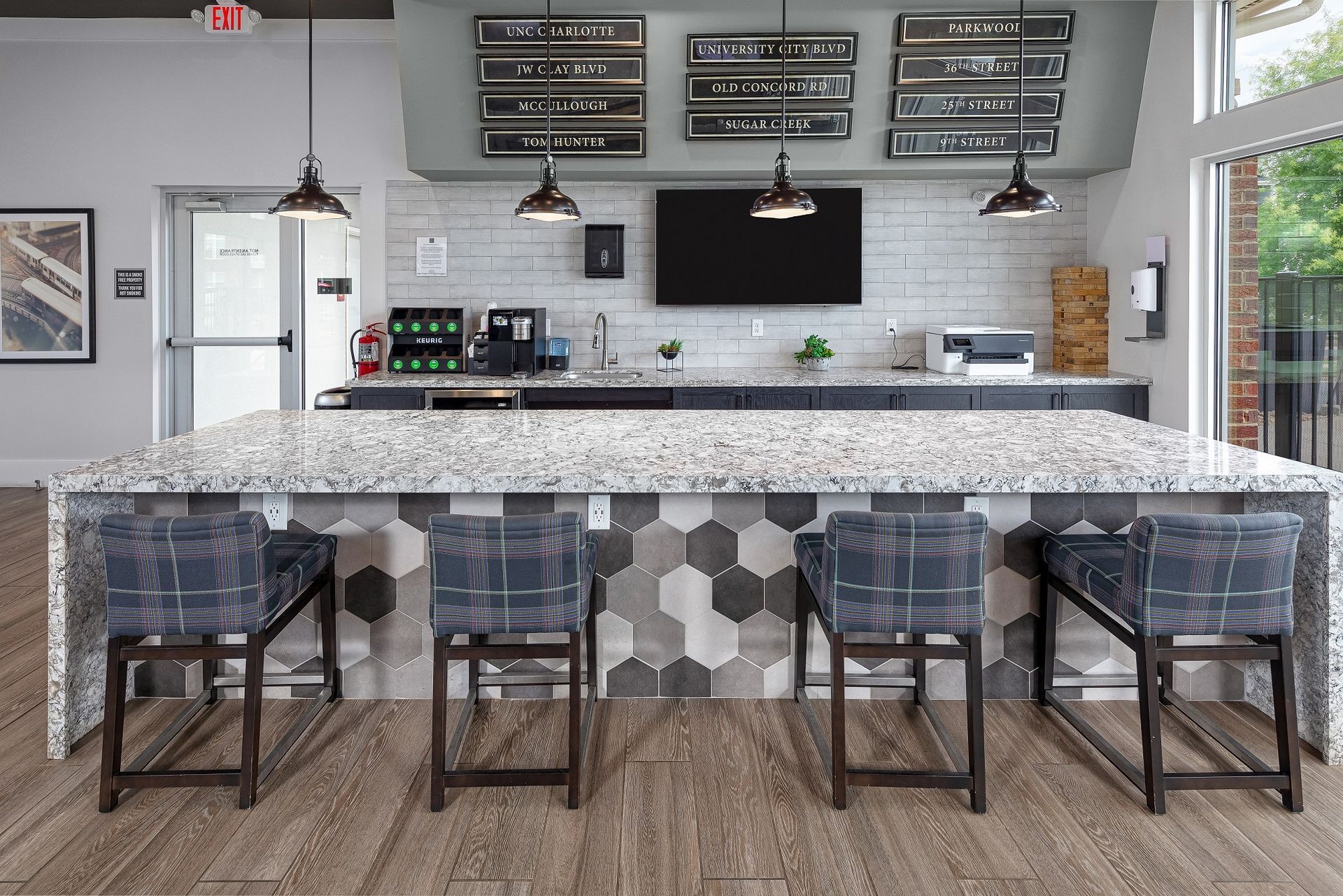 A kitchen with a large island and stools in it.