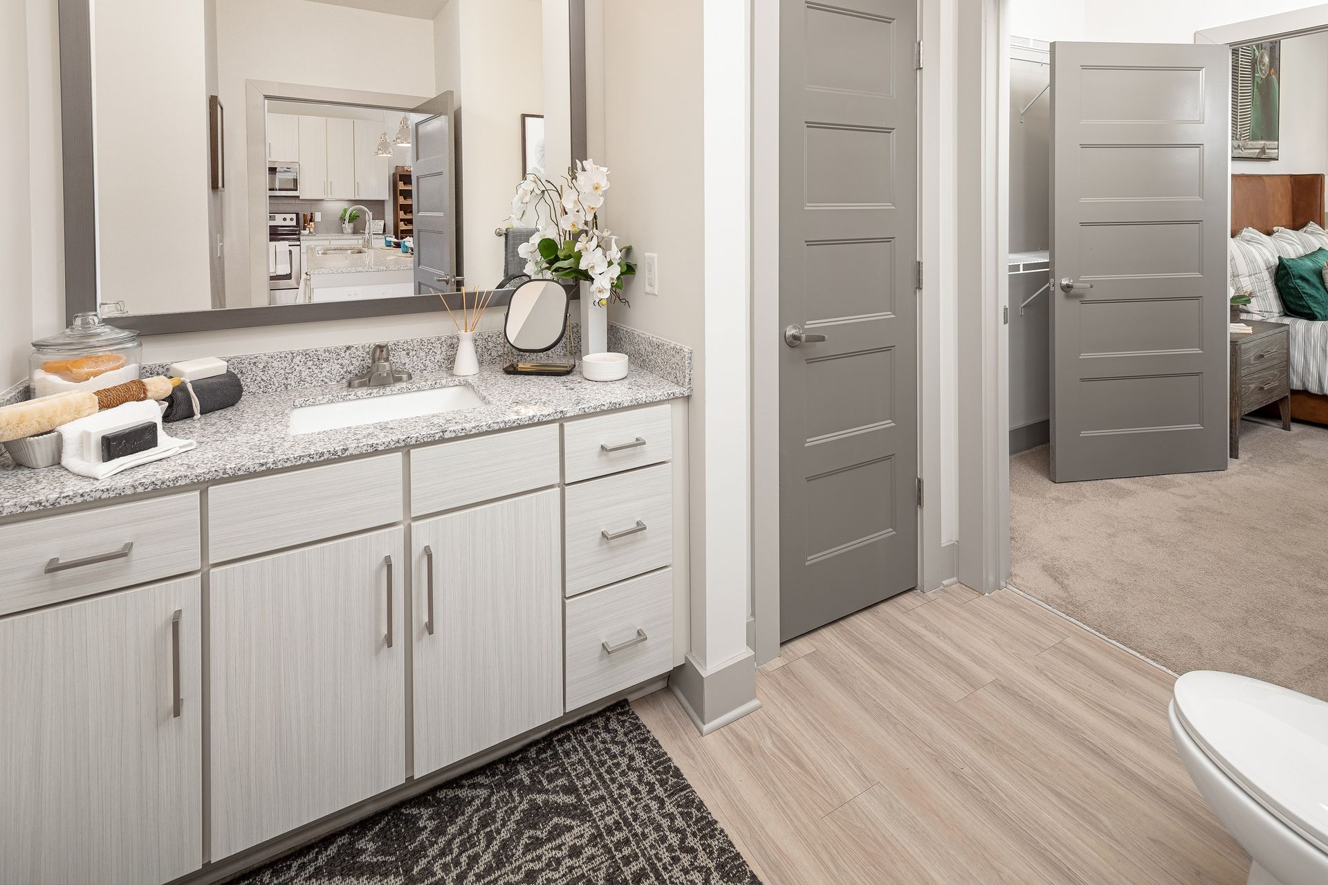A bathroom with a sink , toilet and mirror.