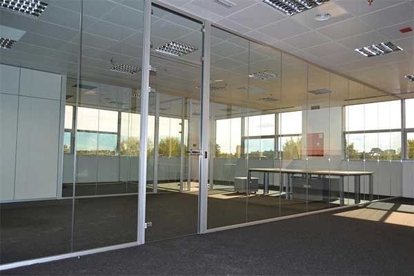 Una habitación con muchas ventanas y paredes de vidrio