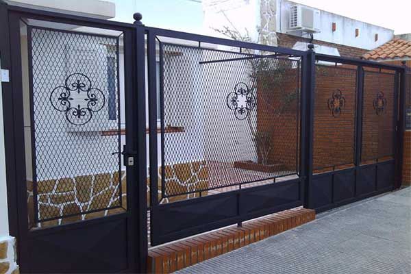 Hay una puerta negra frente a un edificio de ladrillo.