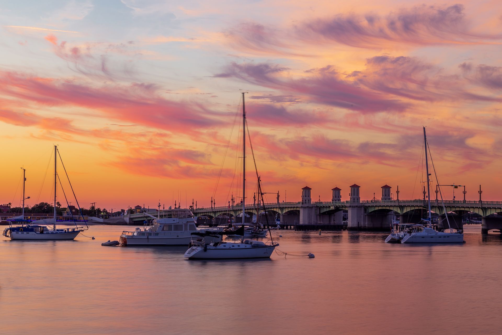 A sunset on a lake with sailboats