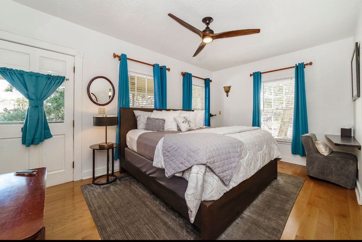 a bedroom with a large bed and a ceiling fan