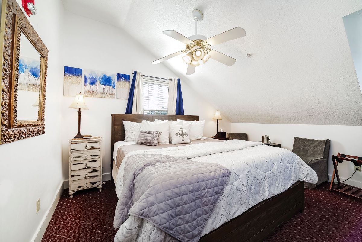 a bedroom with a large bed and a ceiling fan