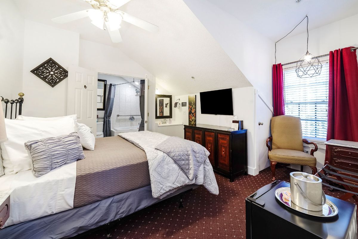 a bedroom with a bed , chair , dresser and television .