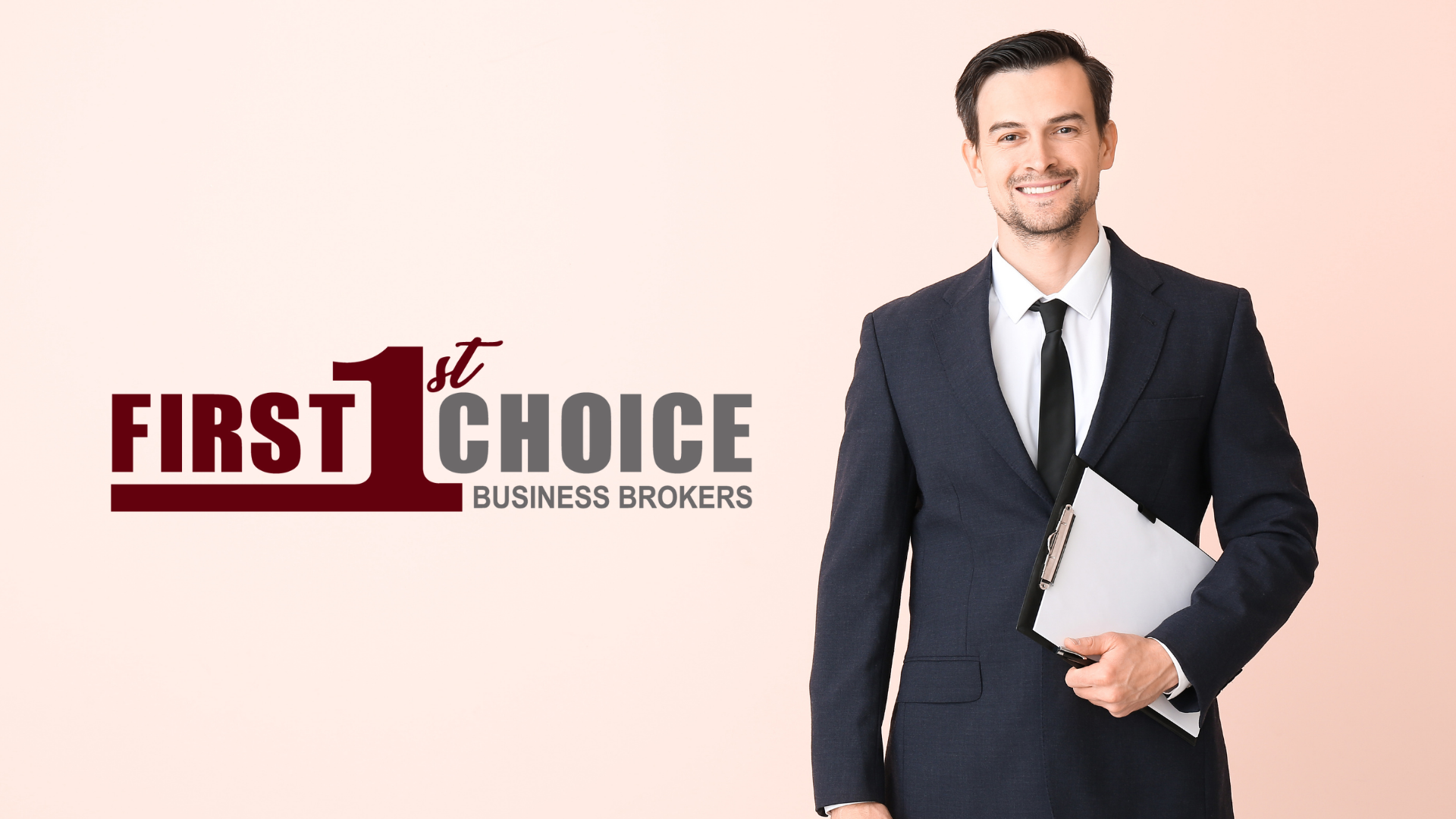 A man in a suit and tie is holding a laptop.