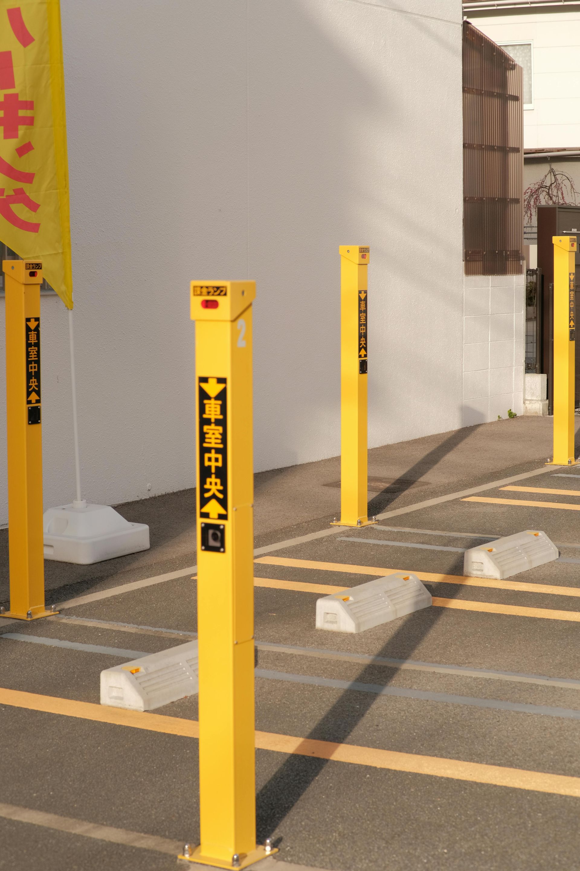 Yellow poles in a parking lot with chinese writing on them