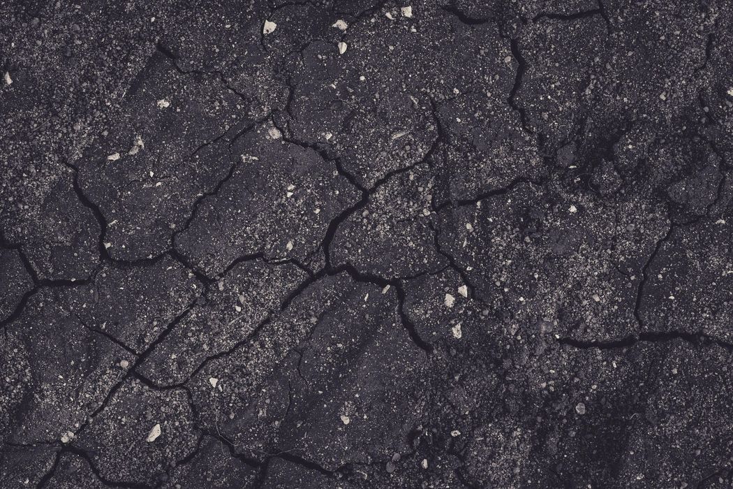 A close up of a cracked asphalt road.