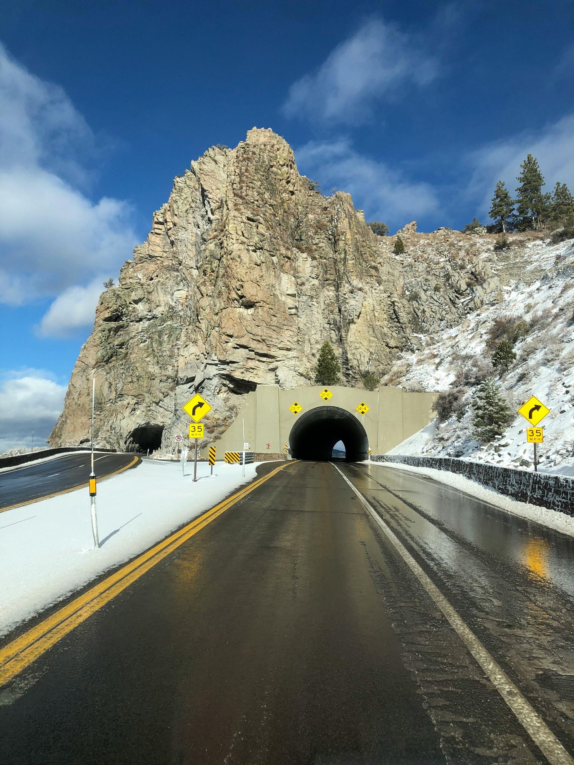 A road going through a tunnel with a mountain in the background