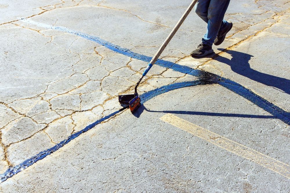 A person is sweeping a parking lot with a broom