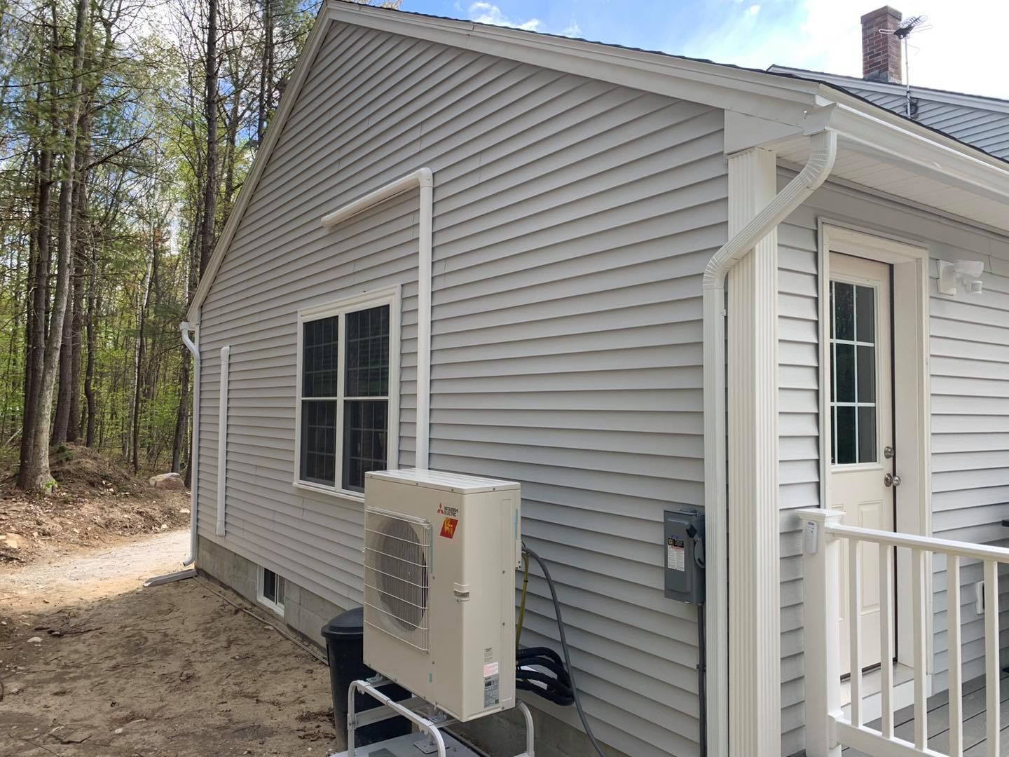 A small house with a large air conditioner on the side of it.
