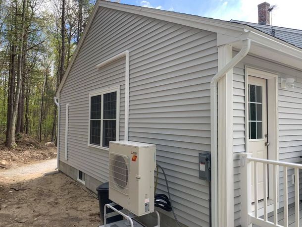 A small house with a large air conditioner on the side of it.