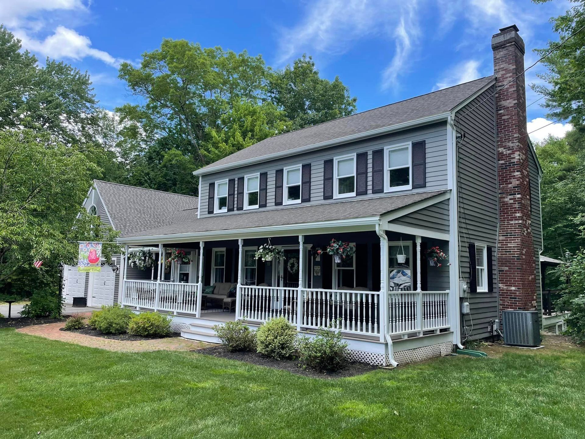 A large house with a large porch on a sunny day.