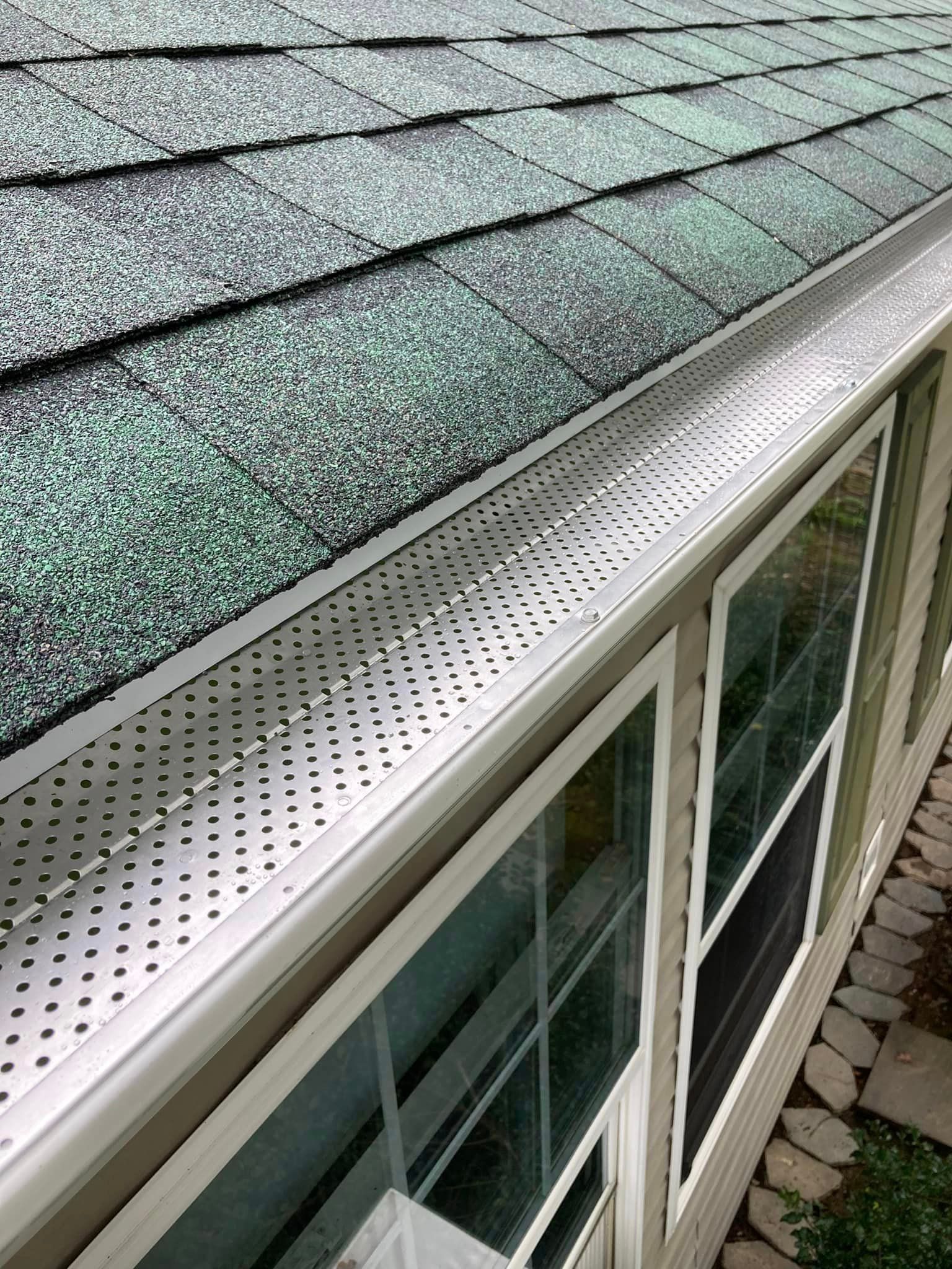 A close up of a gutter on the side of a house.