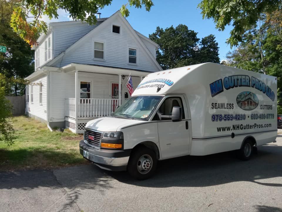 A white van is parked in front of a white house