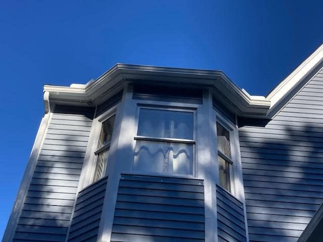 A house with a bay window and a blue sky in the background