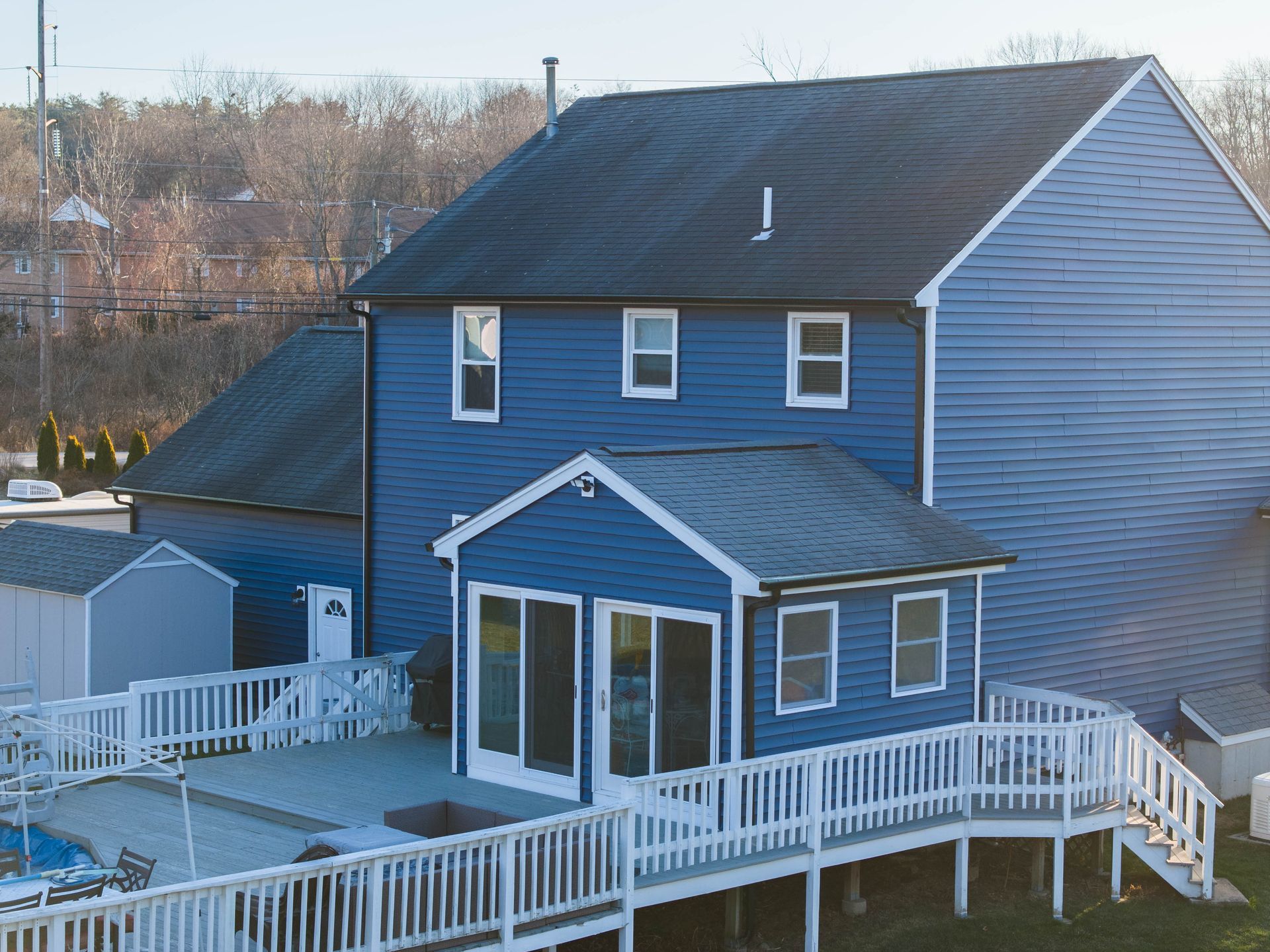 A blue house with a white deck and stairs