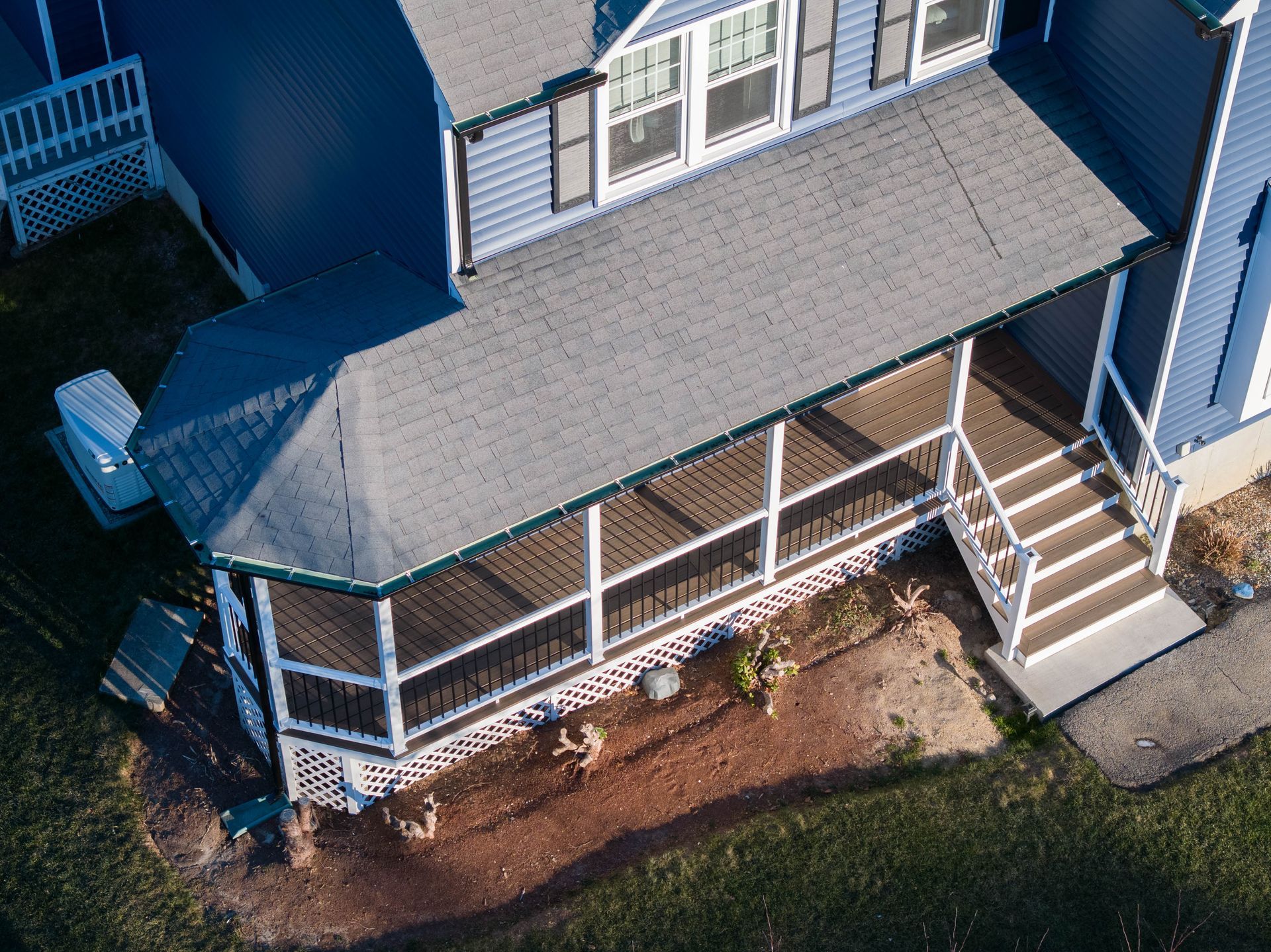 An aerial view of a blue house with a screened in porch