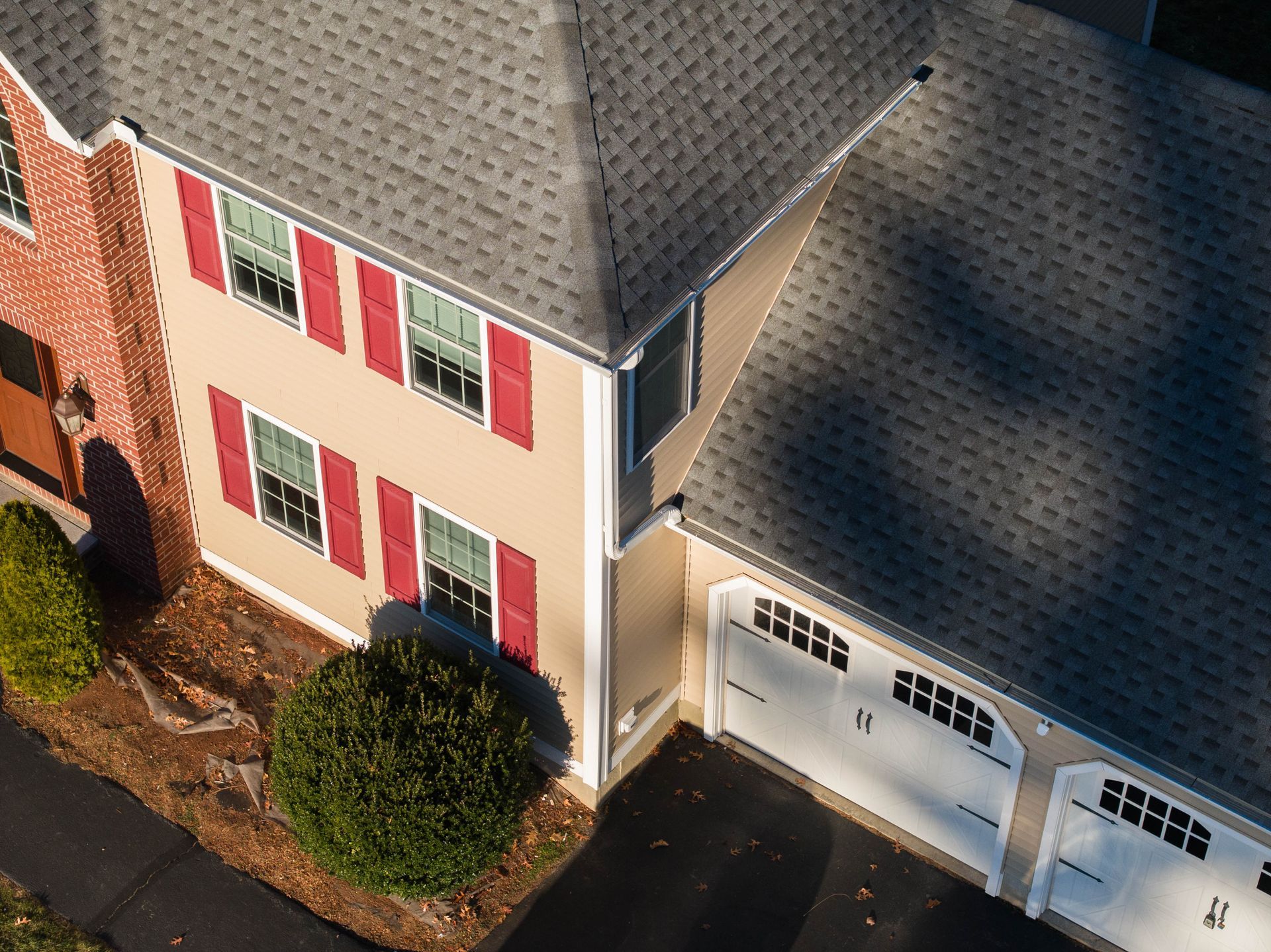 An aerial view of a house with two garage doors and red shutters