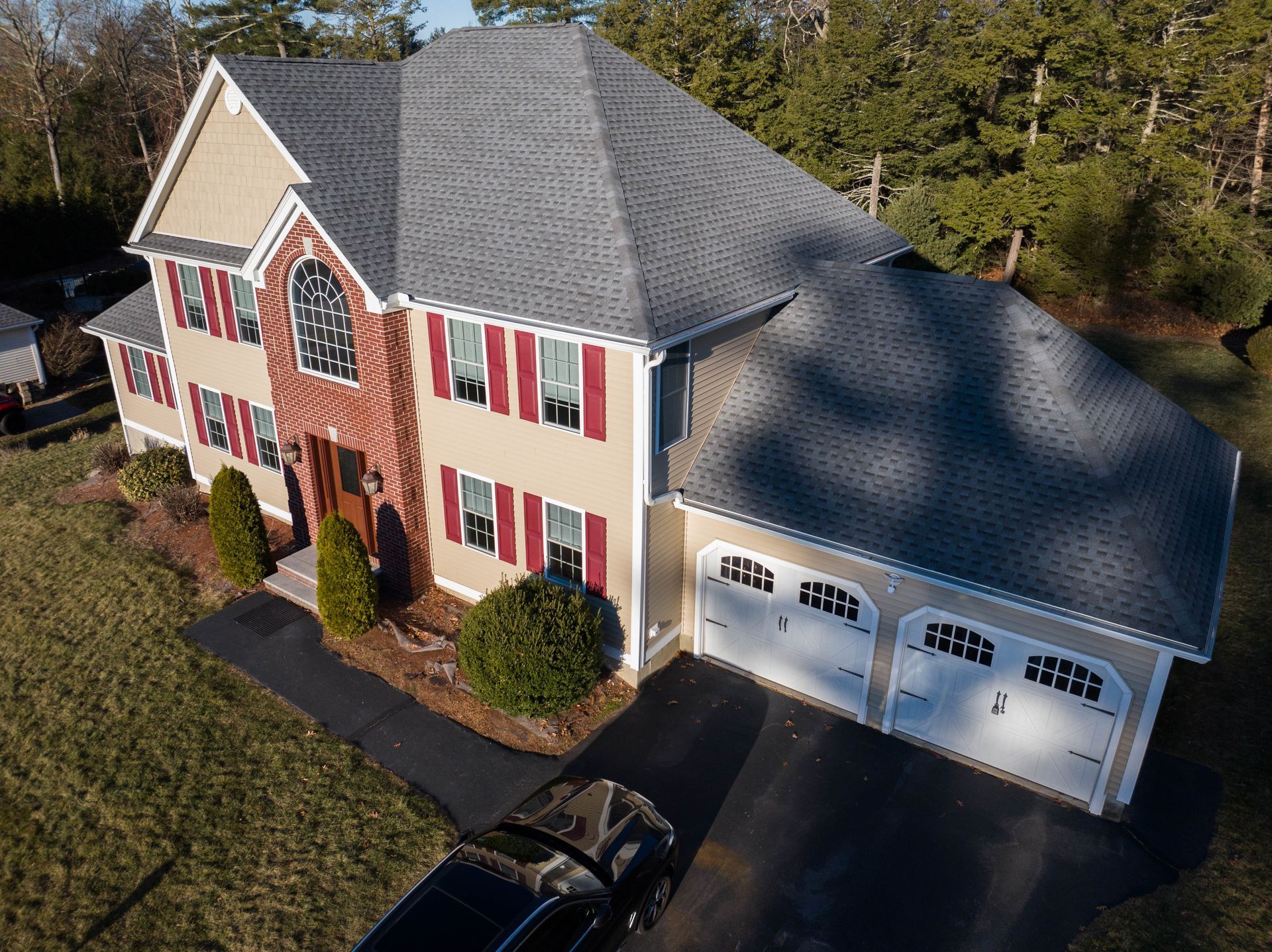 An aerial view of a large house with a car parked in front of it.