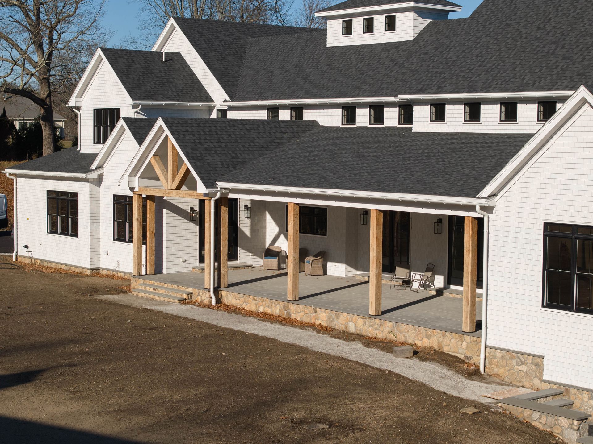 A large white house with a black roof and a porch