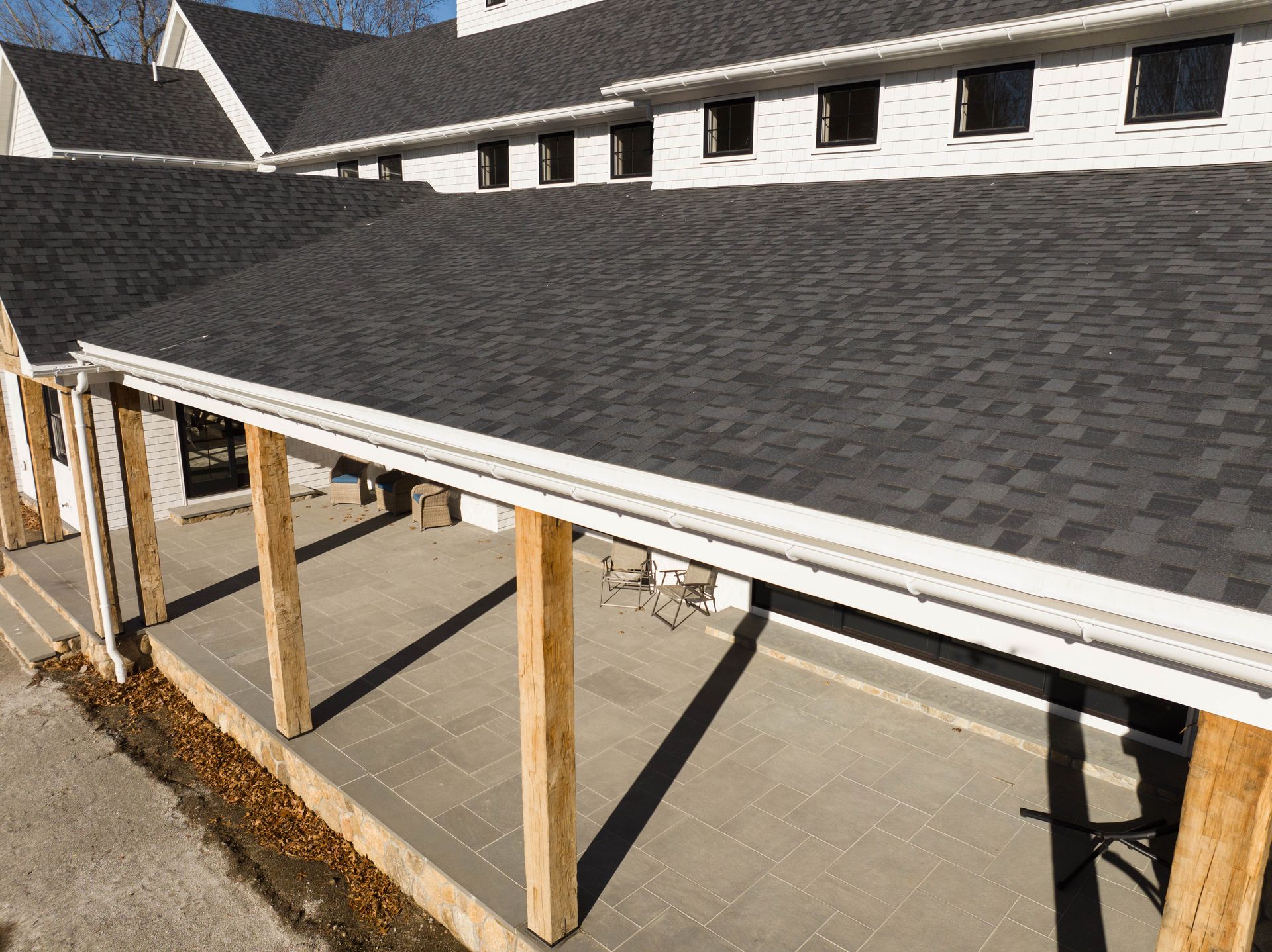 A house with a black roof and a wooden porch.