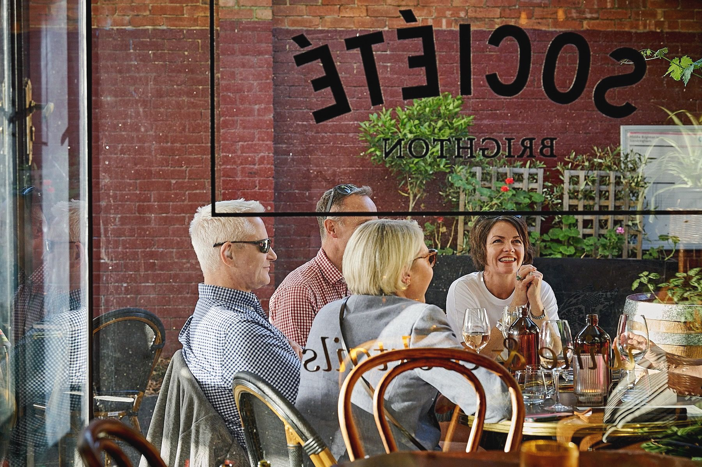 People at a table, dining outside a restaurant with 