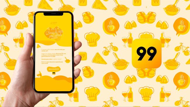 Uma pessoa está segurando um celular na mão em frente a um fundo amarelo.