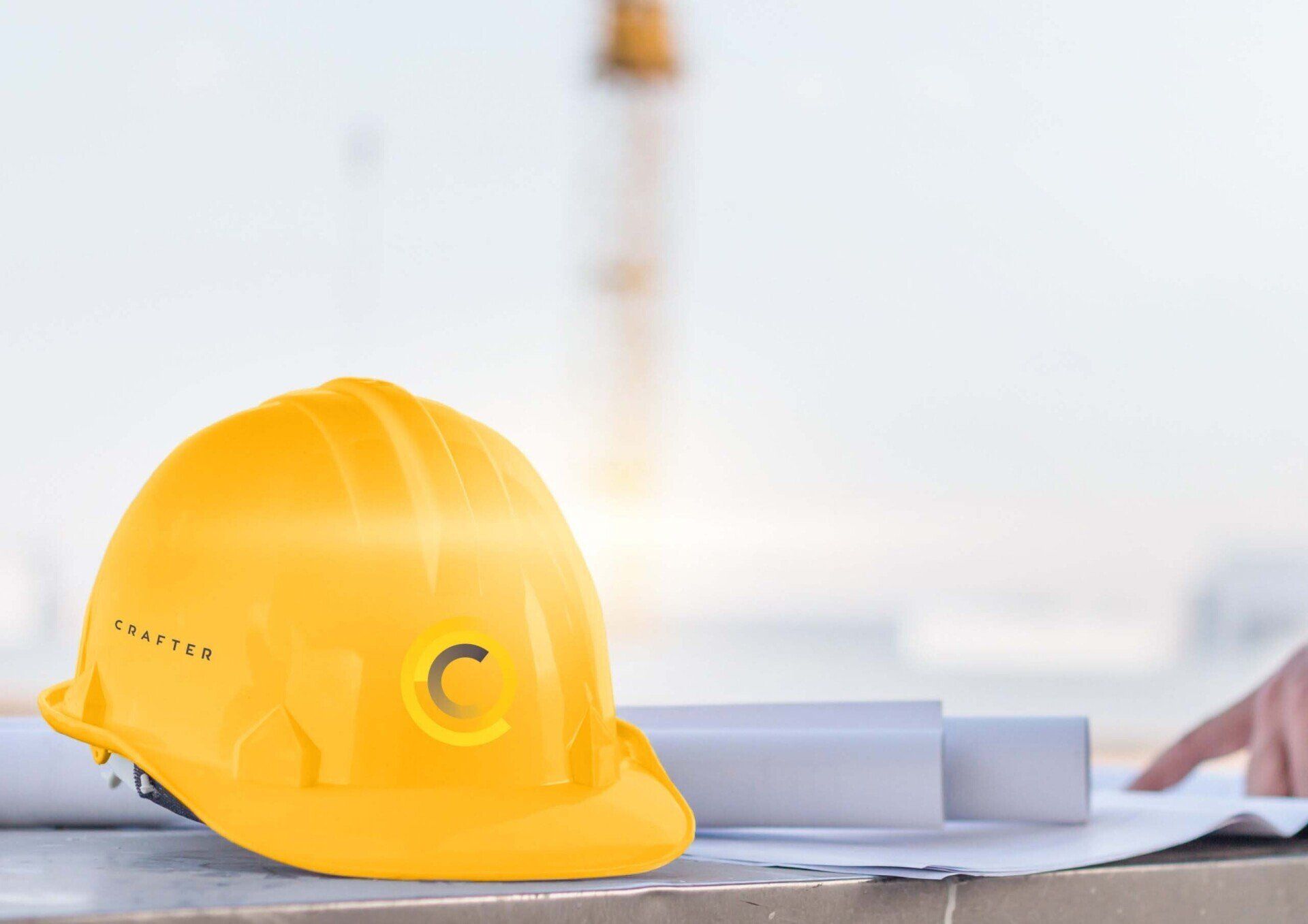 Um capacete amarelo está em cima de uma mesa ao lado de plantas.