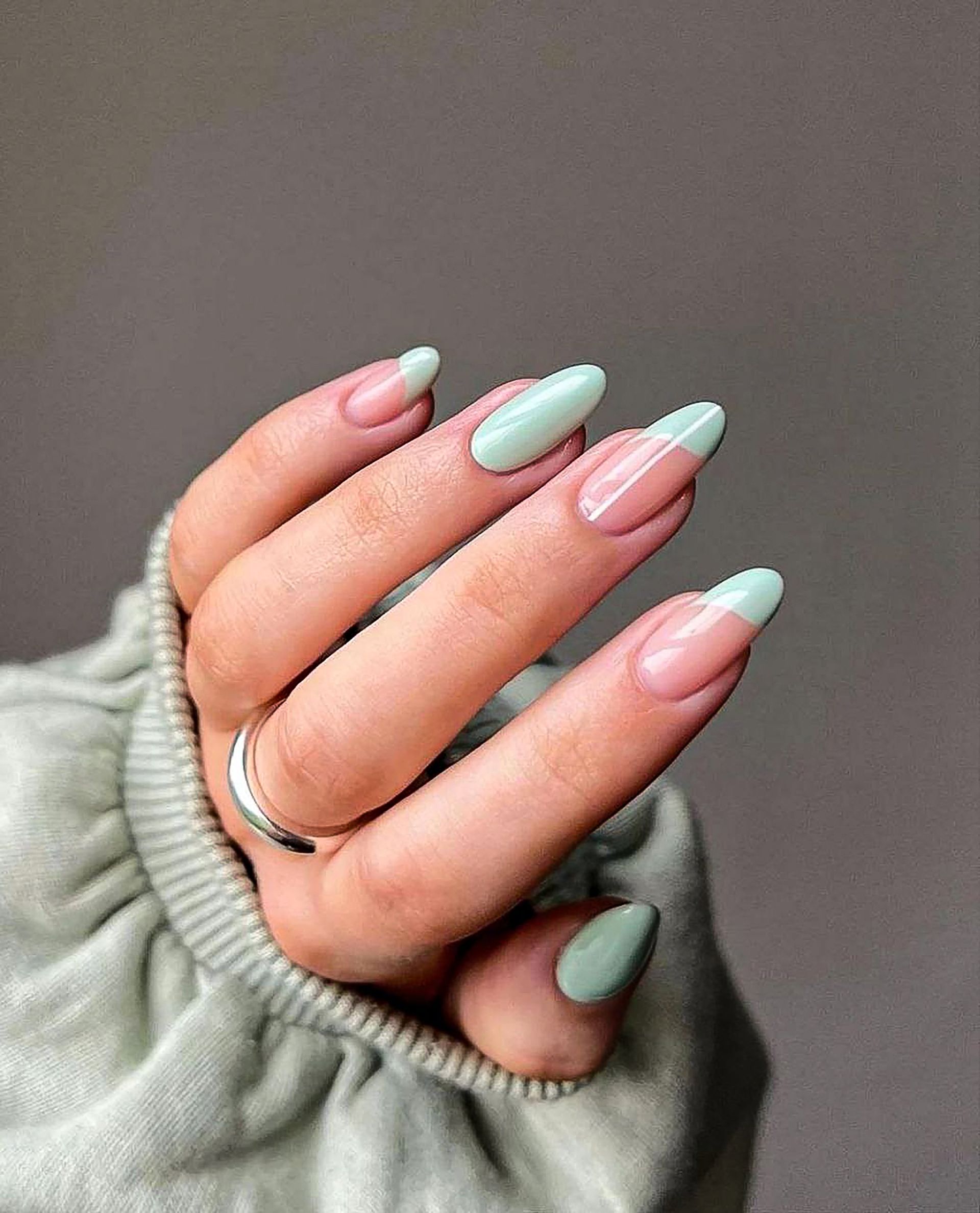 A woman 's hand with long nails and a ring on her finger.