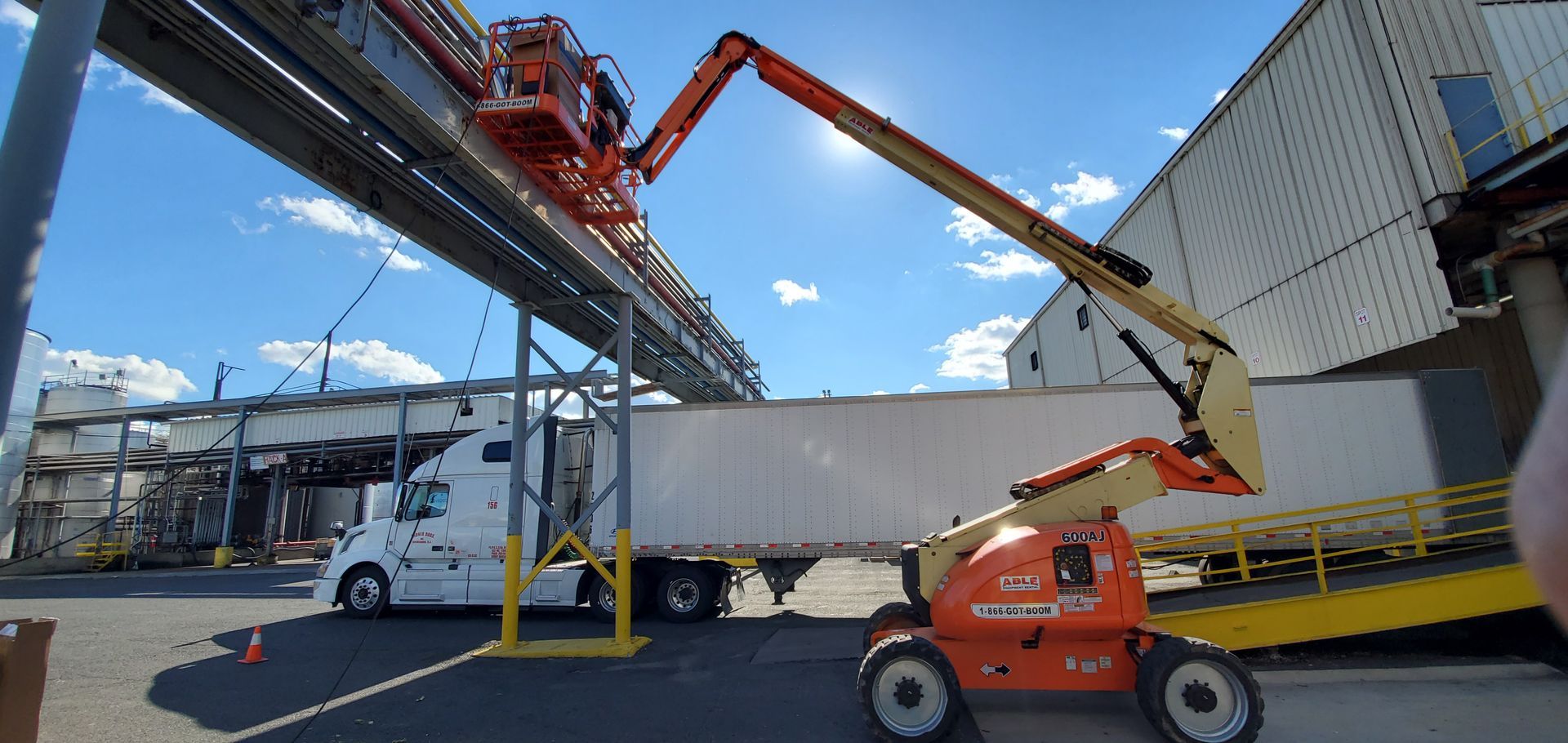 A truck is being towed by a crane in a parking lot.