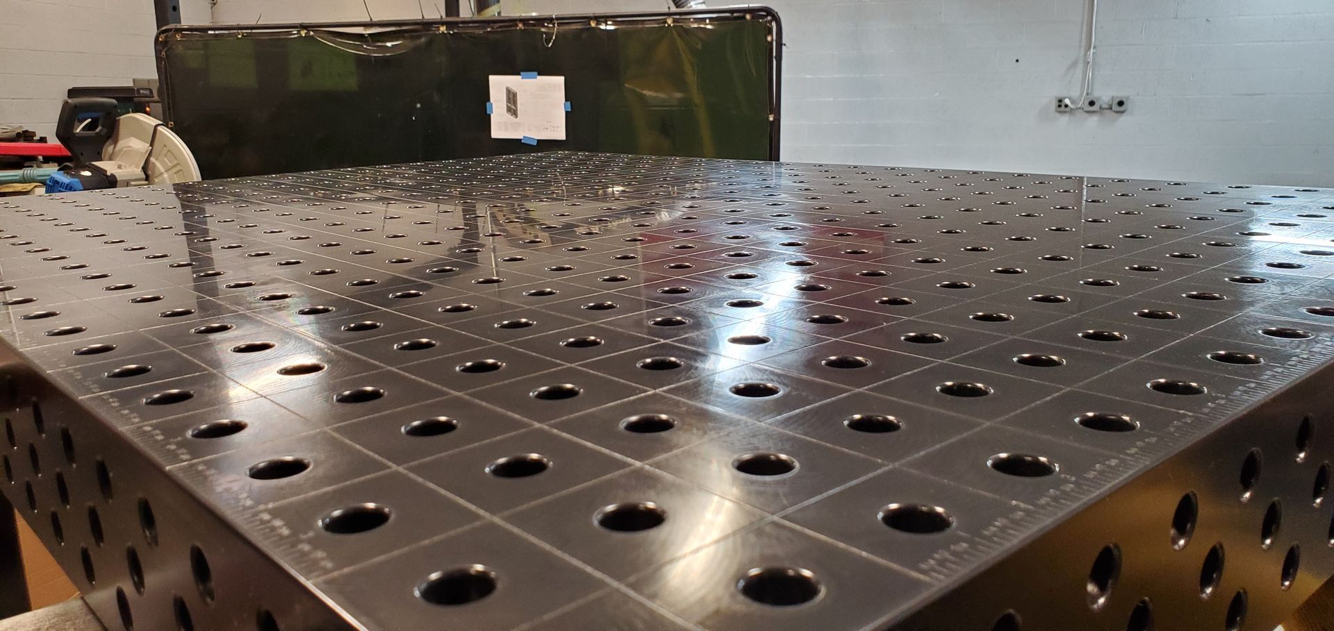 A metal table with holes in it is sitting in a room.