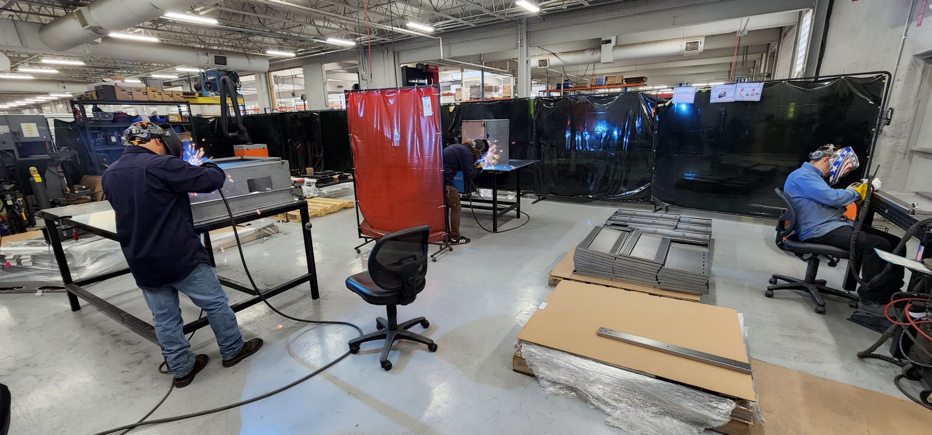 A group of men are welding in a factory.