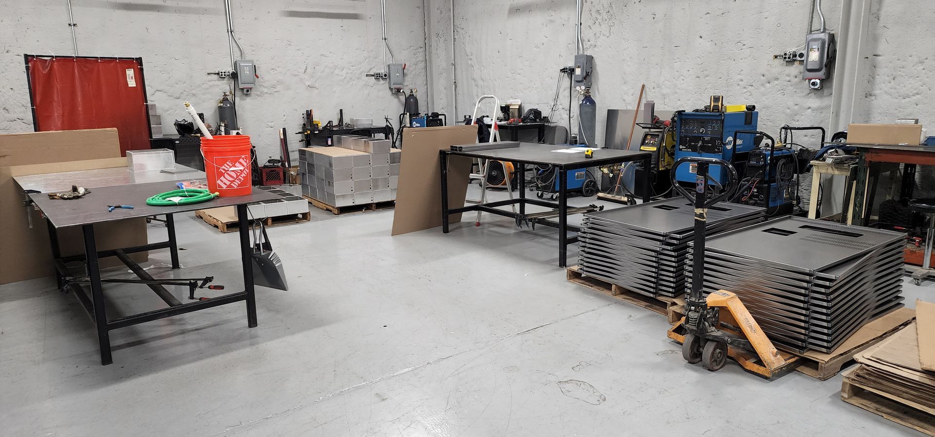 A warehouse filled with lots of tables and pallets.