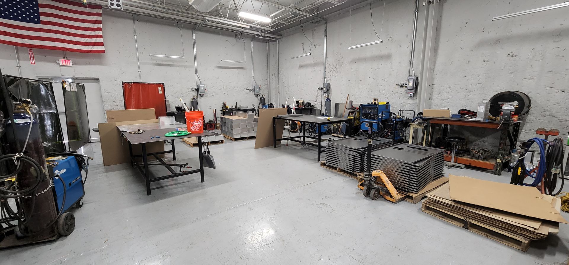 A large room filled with lots of tools and a large american flag.