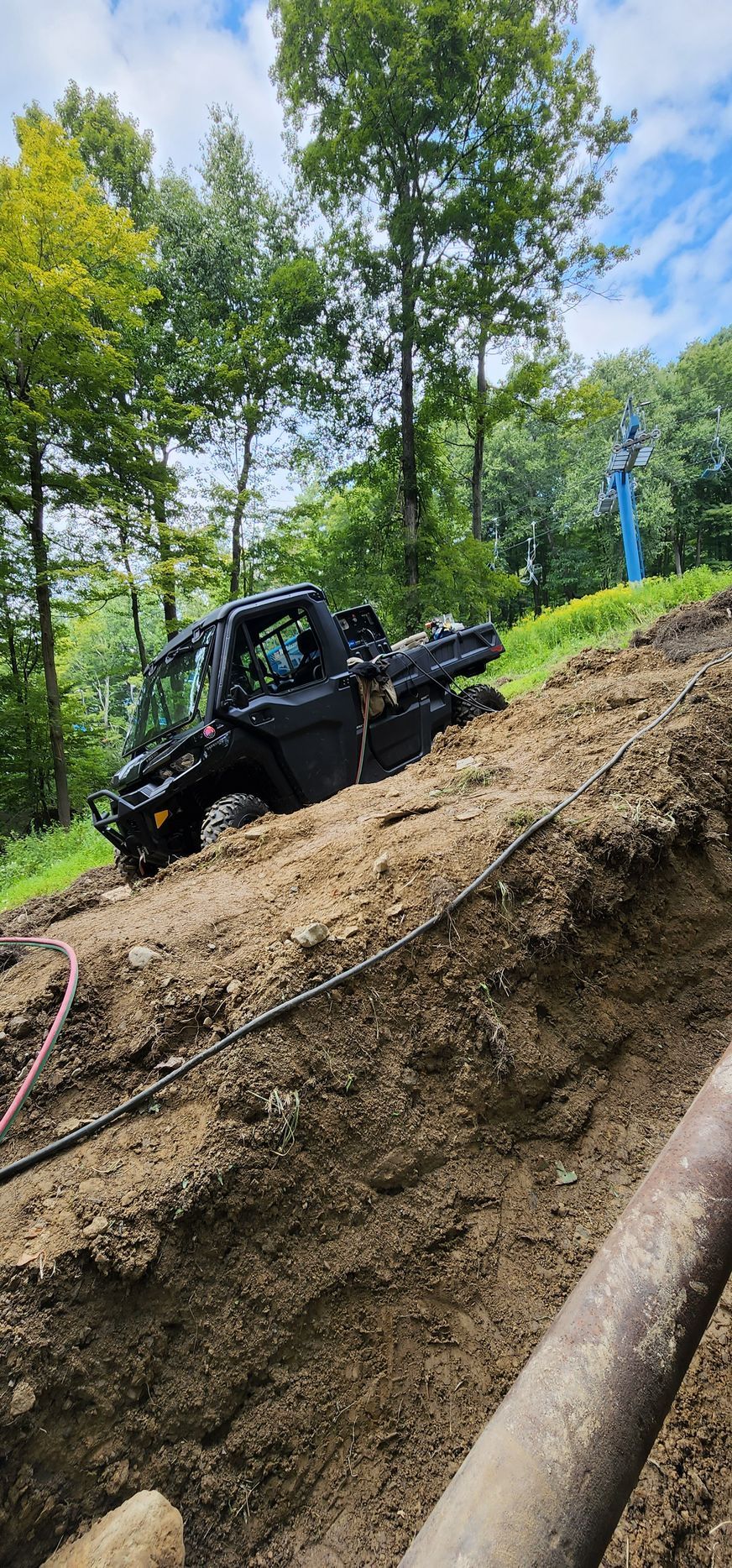 A black truck is sitting on top of a dirt hill.