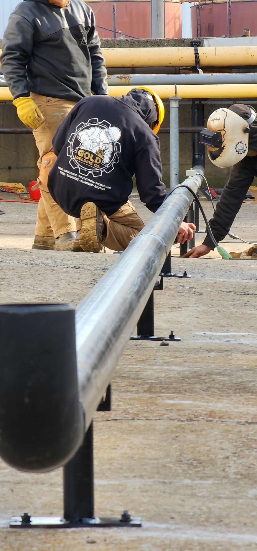 A group of construction workers are working on a pipe.