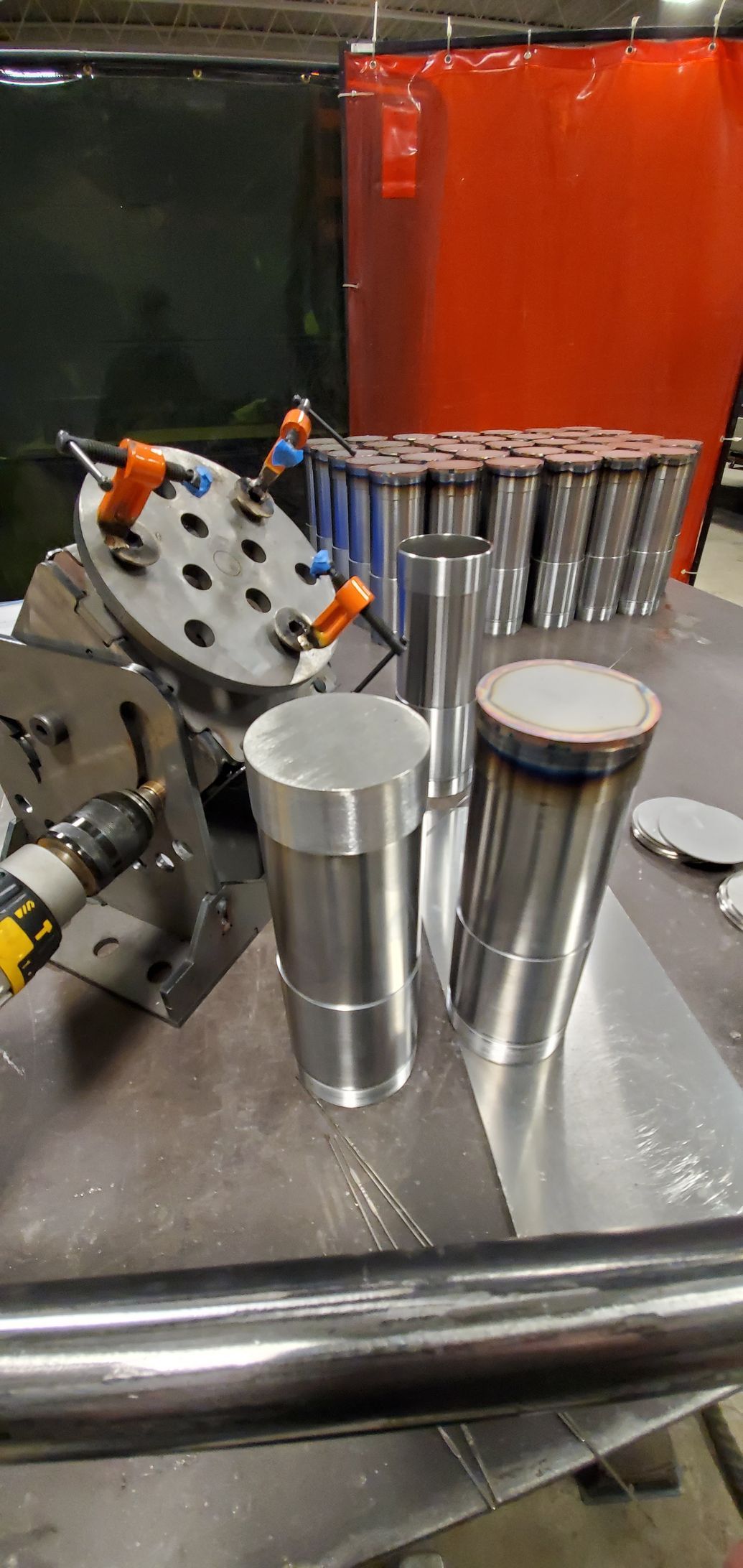 A bunch of metal cylinders are sitting on top of a table.