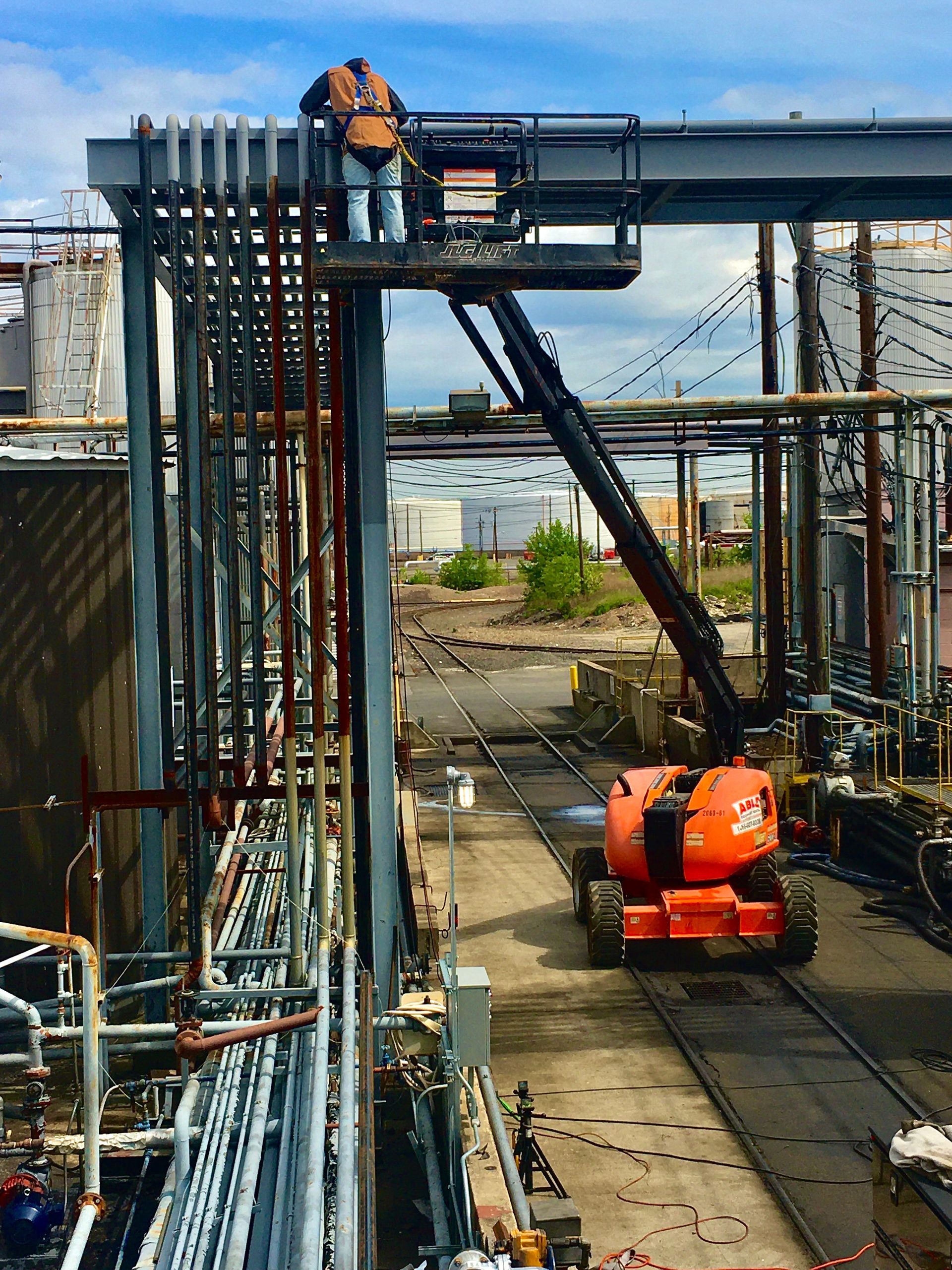 A man is working on a crane in a factory.
